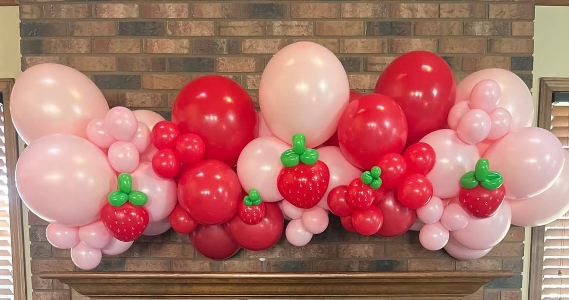 Strawberry-theme organic balloon garland on white backdrop